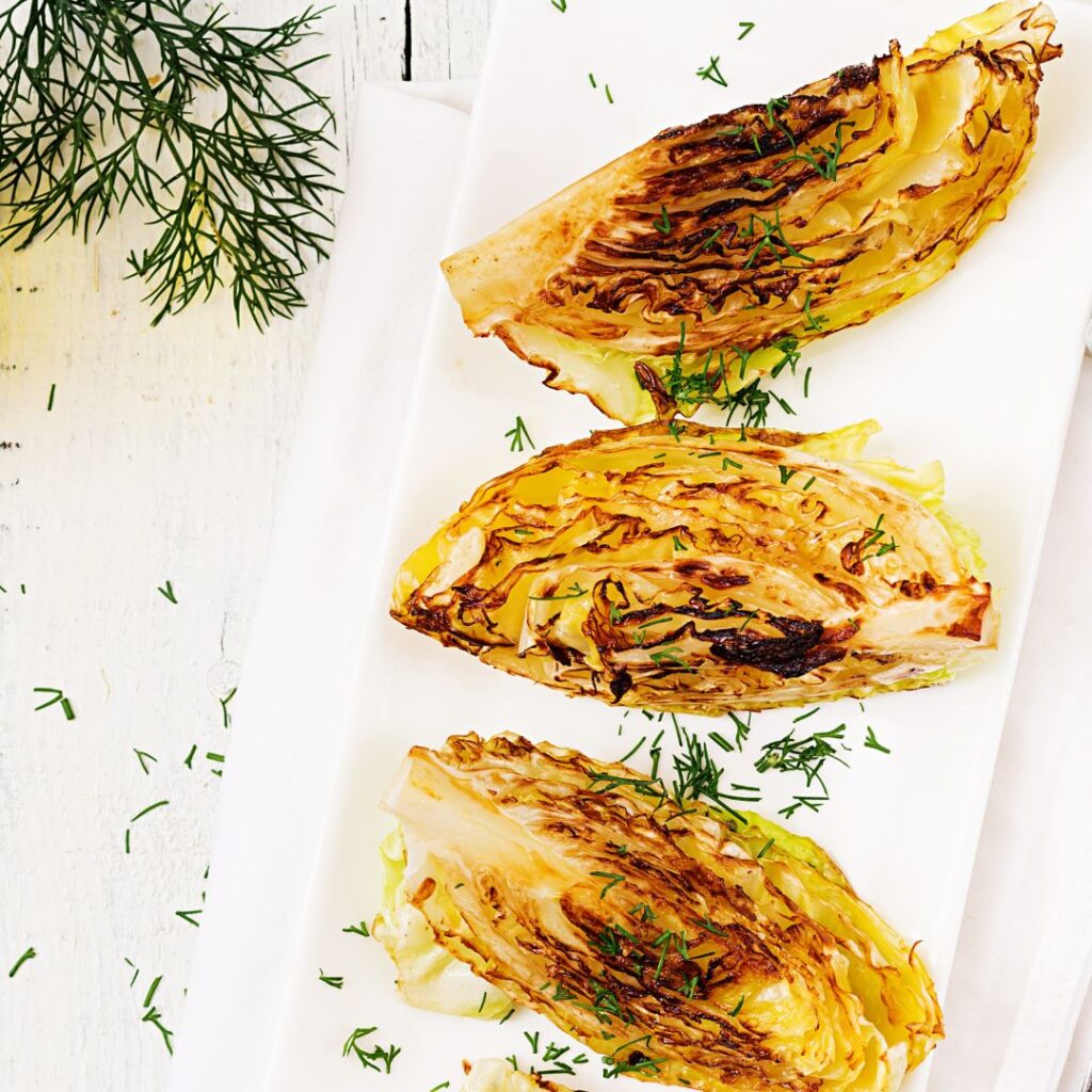 bagt spidskål i airfryer der er serveret på hvid tallerken, og pyntet.